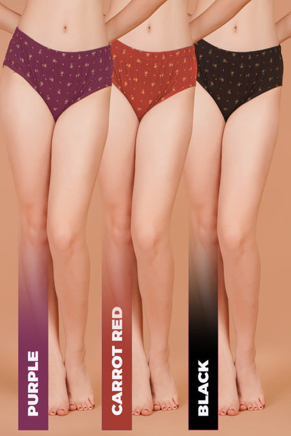 Three pairs of underwear in purple, carrot red, and black on a beige background.